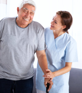 caregiver helping senior man walk