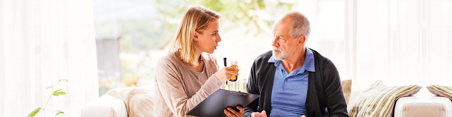 caregiver reminding senior man about his medicine