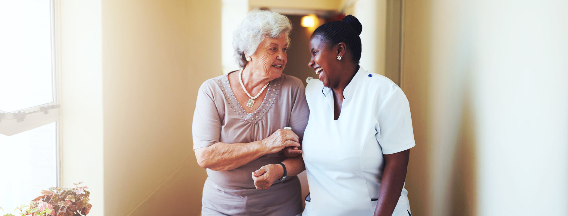 caregiver and senior woman walking together