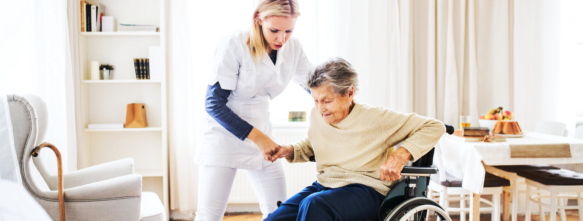 caregiver helping senior woman get up