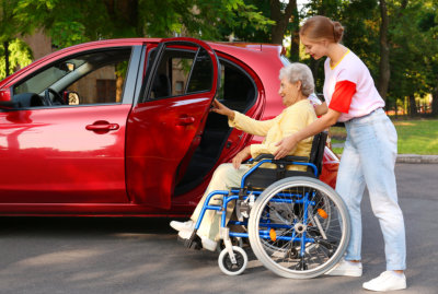 woman helping a senior woman get into the car